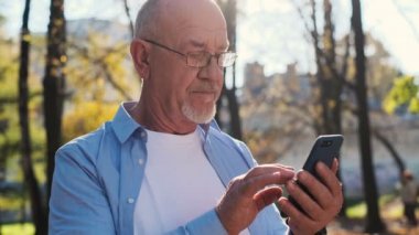 Cep telefonu, holding akıllı telefon, mesaj kullanarak, internet'te sörf ve app dinlenme sırasında parkta kullanarak komuta sizde.