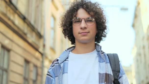 Zavřete Portrét Mladý Usmívající Muž Kudrnatými Vlasy Vlající Větru Brýle — Stock video