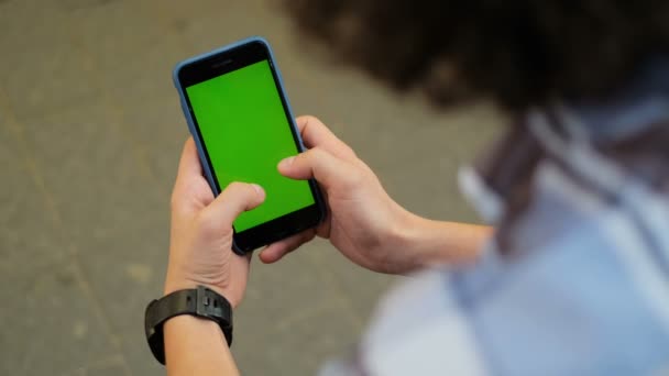 Vista superior del teléfono móvil con pantalla verde y las manos femeninas pegadas en él por el hombre rizado. Al aire libre. Tecla croma en el teléfono inteligente . — Vídeos de Stock