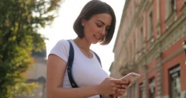 Bir kız bir şey telefon ve kameraya bakışları yazmakta olduğunu