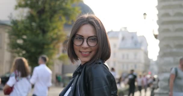 Morena menina está sorrindo e posando para a câmera ao ar livre — Vídeo de Stock