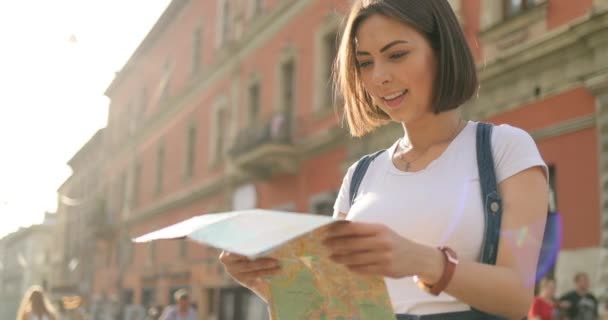 Bir kız bir harita açma ve bir yer için arama — Stok video