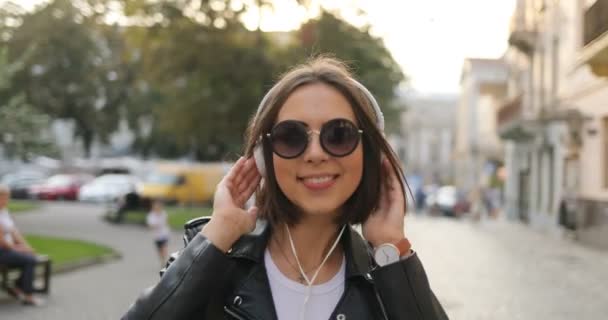 Ein Mädchen mit Kopfhörer tanzt auf der Straße — Stockvideo