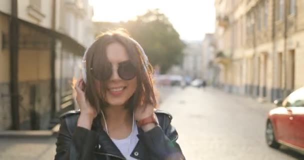 Uma menina de óculos de sol está dançando na rua — Vídeo de Stock