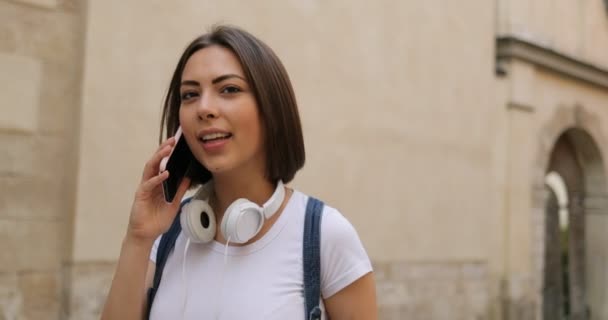 Roztomilá dívka mluví na telefonu na ulici — Stock video