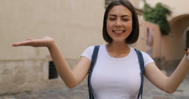 Una hermosa chica está saludando y dando besos de aire en la calle — Vídeos de Stock