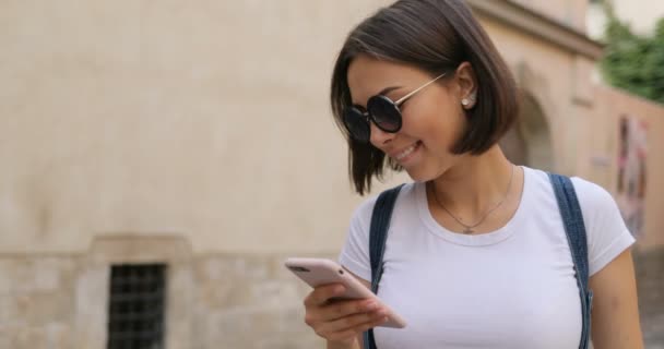 Uma menina está olhando para o telefone e ficando animado — Vídeo de Stock