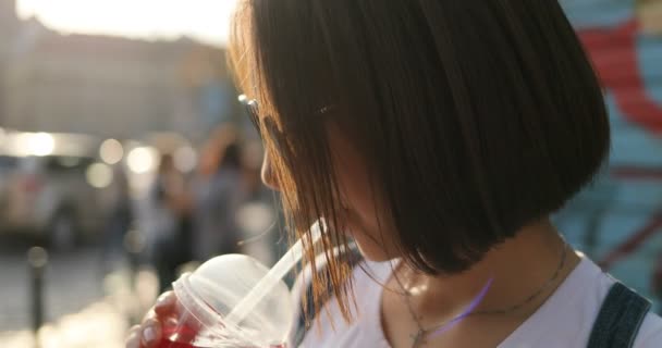 Een meisje drinkt limonade op een zonnige dag — Stockvideo