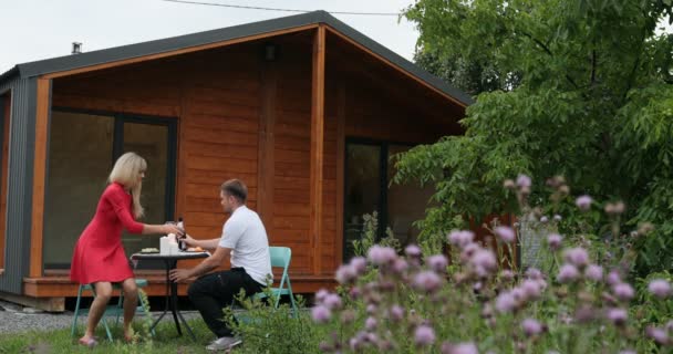 カップルが夕食を屋外とき雨が降り。カップルが夕食を屋外雨が降り始めるとき、テラスにテーブルをかかる男 — ストック動画