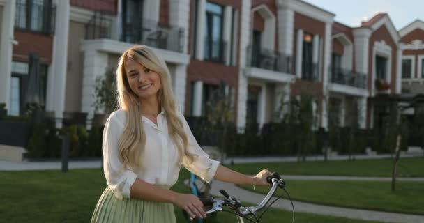 Bella ragazza felice con bici d'epoca, sorride alla macchina fotografica e ride fuori dal divertimento e dalla gioia, in piedi sopra l'edificio europeo — Video Stock