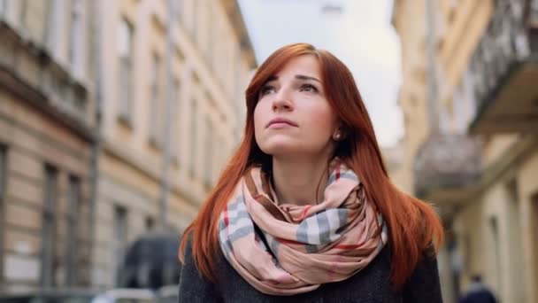 Retrato al aire libre de jengibre sonriente caminando y disfrutando del otoño en el centro de la ciudad. Señora mirando a la cámara. Urbano, calle, estilo de vida — Vídeo de stock