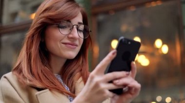 Eski şehrin sokaklarında yürüyüş sırasında cep telefonu uygulaması kullanan kadın. Portre portre, yaşam tarzı, kentsel, bokeh. Cep telefonu, cep telefonu kısa mesaj yazarak ile kadın manifatura