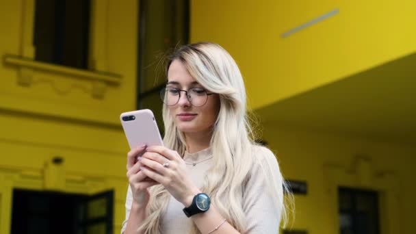 Retrato de chica usando su teléfono inteligente para enviar mensajes de texto y fotos. Mujer navegando por Internet utilizando la aplicación. Mujer desplaza un sitio de redes sociales utilizando el teléfono inteligente . — Vídeo de stock