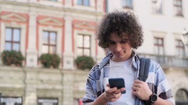 Müzik ve smartphone üzerinde tarama Blogger kullanarak smartphone, kulaklık. Açık, portre. App haber okuma aygıtında, sosyal medya aracılığıyla adam kayar