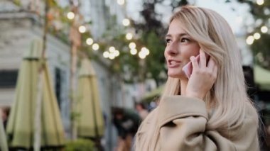 Mutlu genç kadın sokakta yürüme ve kentsel şehir yaşam tarzı zevk cep telefonuyla konuşuyor. Portre kadar kapatın.