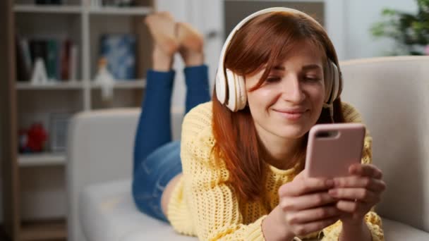 Retrato Una Linda Chica Auriculares Tumbados Sofá Sala Estar Escuchando — Vídeo de stock