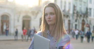 Bir hotebook ve kahve onun elinde tutan ve kamera seyir bir genç attracive iş kadını görünümünü yakın çekim.