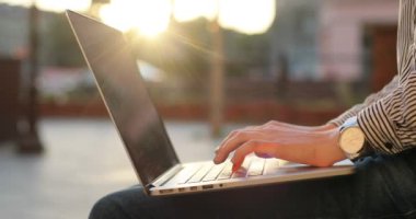 Eller üstünde bir defter yazarak yakından görmek. Bir saat ve bir arka plan üzerinde bir gün batımı ile şık iş kıyafeti.