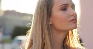 Bir kenara arıyorsunuz ve yüzünü kameraya samimi bir gülümseme ile dönüm neşeli genç bayan. Yakın çekim portre. Güneş blicks.