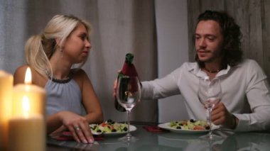 Yakışıklı bir adam şarap dökme ve bir kıza baktığını