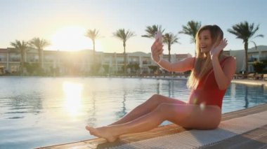 Çekici kız Yüzme Havuzu, rahatlatıcı seyahat macera paylaşımı arkadaşları ile online video aramasında smartphone ile konuş. Görüntülü sohbet sahip, telefonunuzun ve deneyim paylaşımı kadın.