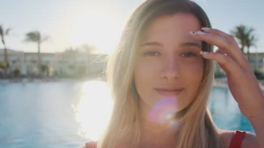 Genç kız, kameraya gülümseyen yüz portresi kapatın. Sıcak güneşli mavi Yüzme Havuz kenarında kırmızı mayo güzel kadın. İyi vakit geçiriyor kız yaz tatili lüks Villa