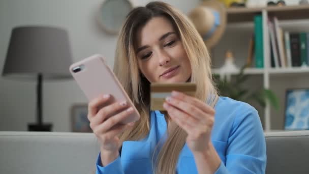 Mujer haciendo el pago en línea con tarjeta de crédito usiing aplicación y teléfono inteligente, compras en línea, tecnología de estilo de vida. Chica entra en el número de tarjeta bancaria en el teléfono inteligente, fácil de pagar utilizando el dispositivo móvil . — Vídeo de stock