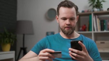 Adam online satın alma, evde akıllı telefon ve kredi kartı kullanarak, alışveriş cep telefonu uygulaması. Portre erkek holding kredi kartı, dijital mobil cihaz uygulaması akıllı iş internet teknolojisi kullanarak kolay ödeme.