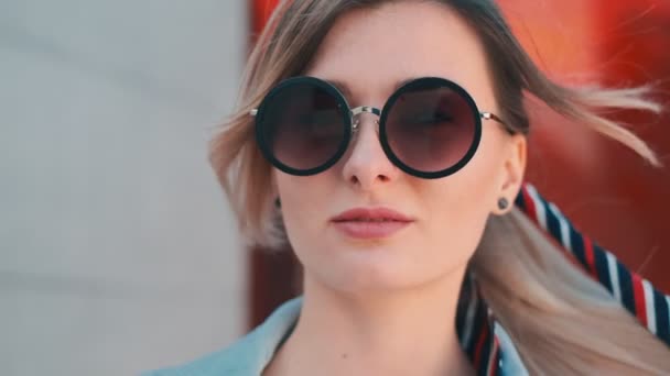 El primer plano de la mujer joven blanca hermosa con el pelo rubio en la cola y en las gafas de sol. Retrato. Afuera. . — Vídeo de stock