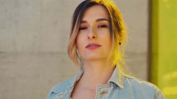 Retrato de la hermosa joven caucásica mirando directamente a la cámara y sonriendo. Al aire libre. De cerca. . — Vídeo de stock