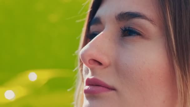 Gros plan du visage de la belle jeune femme caucasienne regardant la caméra et souriant joyeux à l'extérieur sur le fond de verre jaune. Portrait . — Video