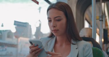 Neşeli gülümseyen sevimli genç öğrenci kız portresi gidip ederken cep telefonu kullanarak toplu taşıma sürme. Sevimli kadın arkadaşı ile sohbet.