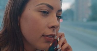 Yakın çekim yüz portre kız toplu taşıma cep telefonu konuşuyor. Mutlu çekici kadın şehir tramvay pencereyakınında oturma, akıllı telefon konuşurken ve kamera bakarak.