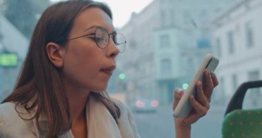Beyaz tenli, gözlüklü, güzel bir kadın tramvayda ya da otobüste oturup eve dönerken akıllı telefondan dinleyip mesaj atıyor. Kapat..