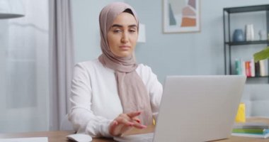 Laptop 'ta çalışan, bilgisayardan haber okuyan, internet öğretmeniyle internetten ders çalışan, evdeki sorunları çözen müslüman kız öğrencilere yakın çekim. Ciddi kadın ilham ve fikir arıyor..