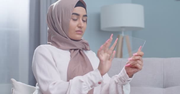 Primer plano de la mujer musulmana en hijab, utilizando una tableta de vidrio futurista con la última tecnología holográfica avanzada. Concepto de: futuro, tecnología, smartphone, realidad aumentada — Vídeos de Stock