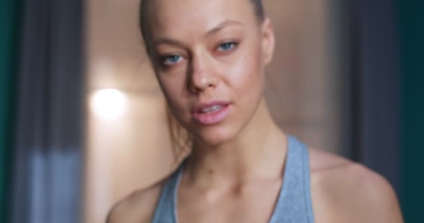 Close-up portret van gelukkig geconcentreerde gemotiveerde fitte vrouw die naar de camera kijkt. Jonge bodybuilding meisje tijdens training workout sessie. Sport en fitness. Training, training en wellness concept. — Stockvideo