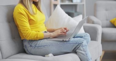 Tatilde evde bilgisayar başında çalışan genç bir ofis çalışanının portresini kapat. Kanepede otururken e-postalarına cevap ver. Karantinada çalışan bir iş kadını..