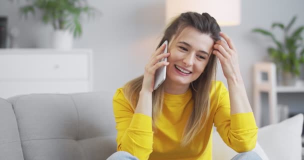 自宅のオフィスで黄色のセーターの少女の肖像画、座って、彼女の婚約者と電話で話して、彼女のボーイフレンドといちゃつく。現代生活、コミュニケーション、関係、ライフスタイルの概念. — ストック動画