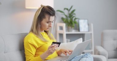 Kredi kartı tutan mutlu genç bir kadının portresini yakın plan çek. Evde cep telefonu ödemelerini kullanıyormuş. Müşteriler akıllı telefondan nakit para alıyormuş. E-bankacılık uygulama servisi