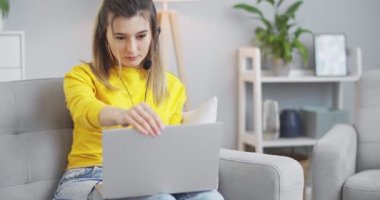 Sarı elbiseli genç kız arkadaşlarını aramak için bilgisayarı açıyor, bilgisayar ekranına el sallıyor, arkadaşlarına haber veriyor, dedikodu yapıyor. Modern hayat kavramı, iletişim, ilişkiler, yaşam tarzı..