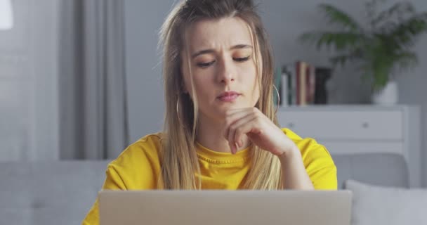 Mujer triste preocupado responder a los mensajes en un chat en las redes sociales, mirando a la pantalla de la computadora en el pensamiento. Chica decepcionada trabajando en el portátil . — Vídeo de stock