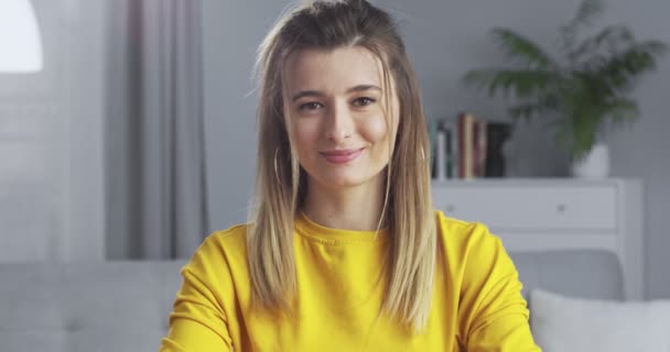 Bonita sorridente jovem confiante com rosto bonito olhando para câmera posando sozinho em casa escritório. Menina milenar feliz estudante profissional close up retrato frontal . — Vídeo de Stock