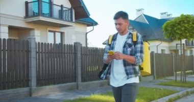 Yetişkin beyaz erkek kurye müşterilerin evini aramak için sipariş veriyor. Caddede bisikletle yürüyen çekici teslimatçı adresi kontrol etmek için akıllı telefonu kullanıyor. Teslimat konsepti.