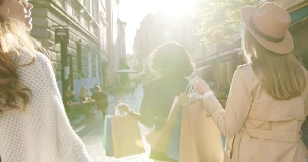 Nahaufnahme verschiedenster multiethnischer Frauen an sonnigen Tagen im Freien. Rückseite der schönen kaukasischen Mädchen mit Hut, die auf der Straße in der Stadt mit Einkäufen. Afroamerikanerin in der Stadt. Einkaufskonzept — Stockvideo