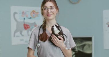 Veteriner kliniğinde muayeneden sonra ortadaki planda kadın veteriner kobay sahibini bekliyor. Gözlüklü ve steteskoplu bir veteriner. Konsept hayvan bakımı, veteriner.