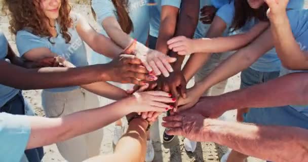 People of different ages and races are united to protect environment from pollution. Happy volunteers stacking hands together to cheer and boost team spirit. Friendship, teamwork, volunteering. — Stock Video