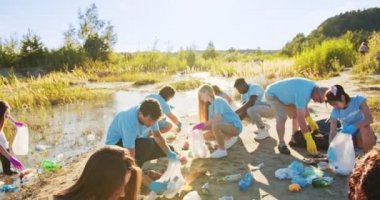 Dışarıdaki çöpleri toplayan çok ırklı bir gönüllü grubu. Eldivenli tutkulu çevreciler plastik şişe, torba, atık, mukavva topluyorlar. Çevre kirliliği, göç kavramı.