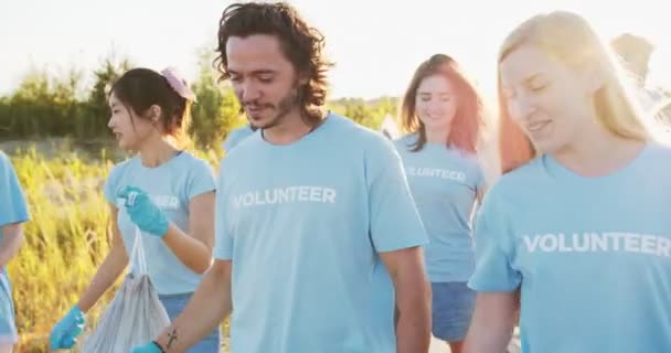 Un grupo de voluntarios de diferentes edades terminan el trabajo y se van a casa después del trabajo duro. Activistas eco multiétnicos divirtiéndose, chocando los cinco y riendo. Trabajo en equipo, voluntariado, concepto de bienestar. — Vídeos de Stock