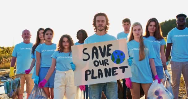 Un grupo de eco activistas protestando contra la contaminación del planeta Tierra. Voluntarios multiétnicos con póster Save Our Planet mirando a la cámara. Huelga, protesta, concepto de conservación ambiental. — Vídeo de stock